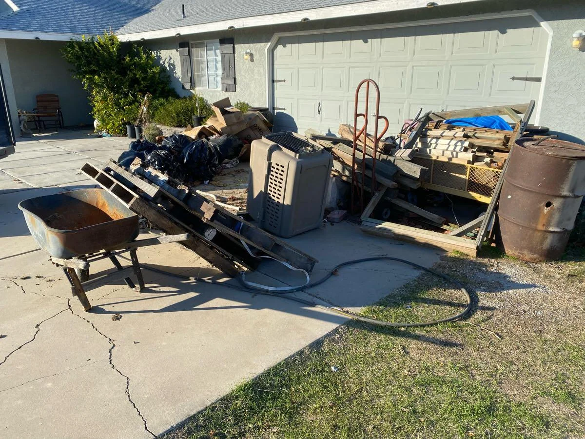 Furniture and mixed debris gathered on a driveway