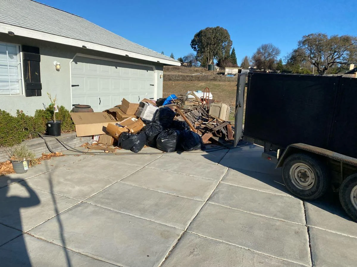 Bagged material and boxes beside a dump trailer