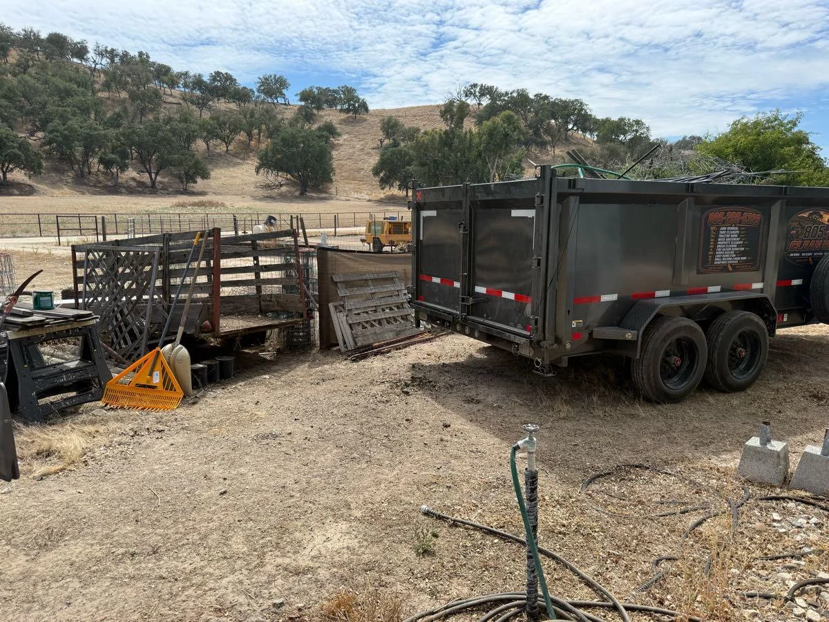 Dump trailer beside materials at a rural property